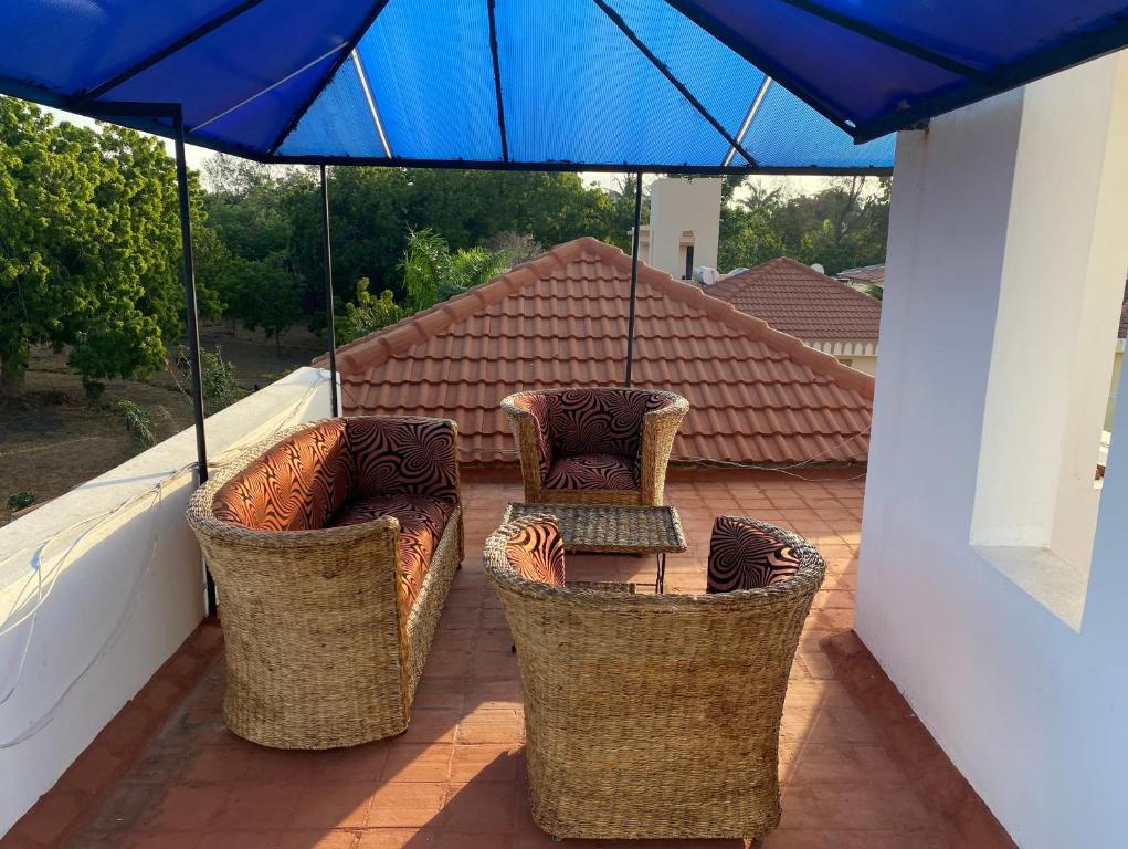 a patio with two chairs and a table and an umbrella at Nyali Villa in Mombasa