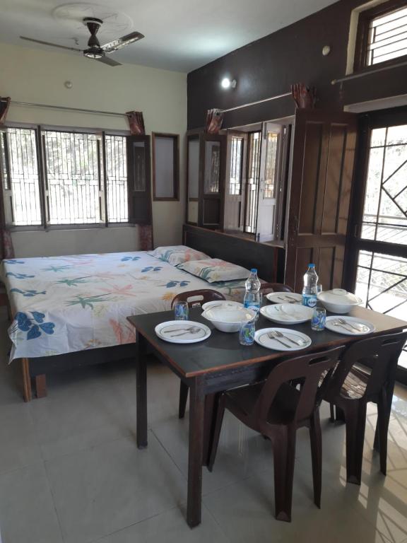 a dining room with a table and a bed at Jungle View Home Stay in Dogadda