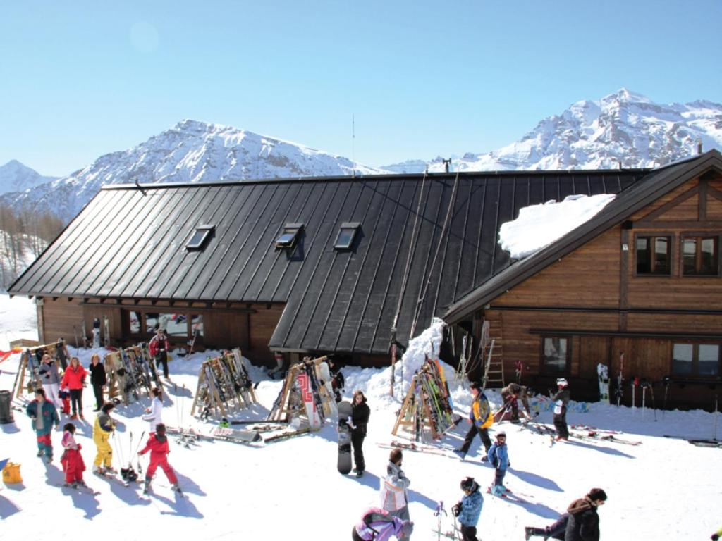 a group of people standing in the snow in front of a building at Rifugio 2000 in Alpe Ciamporino