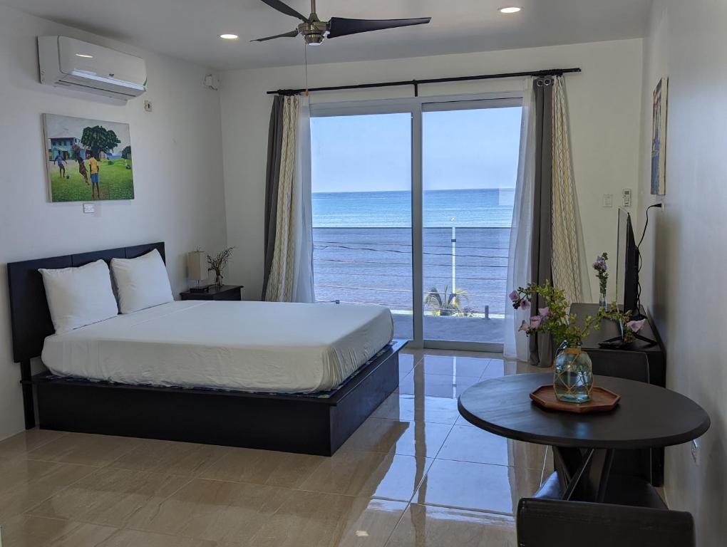 a bedroom with a bed and a view of the ocean at Inn The Town in Port Antonio