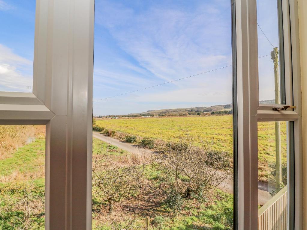 a window view of a field from a house at East Cottage in Malton