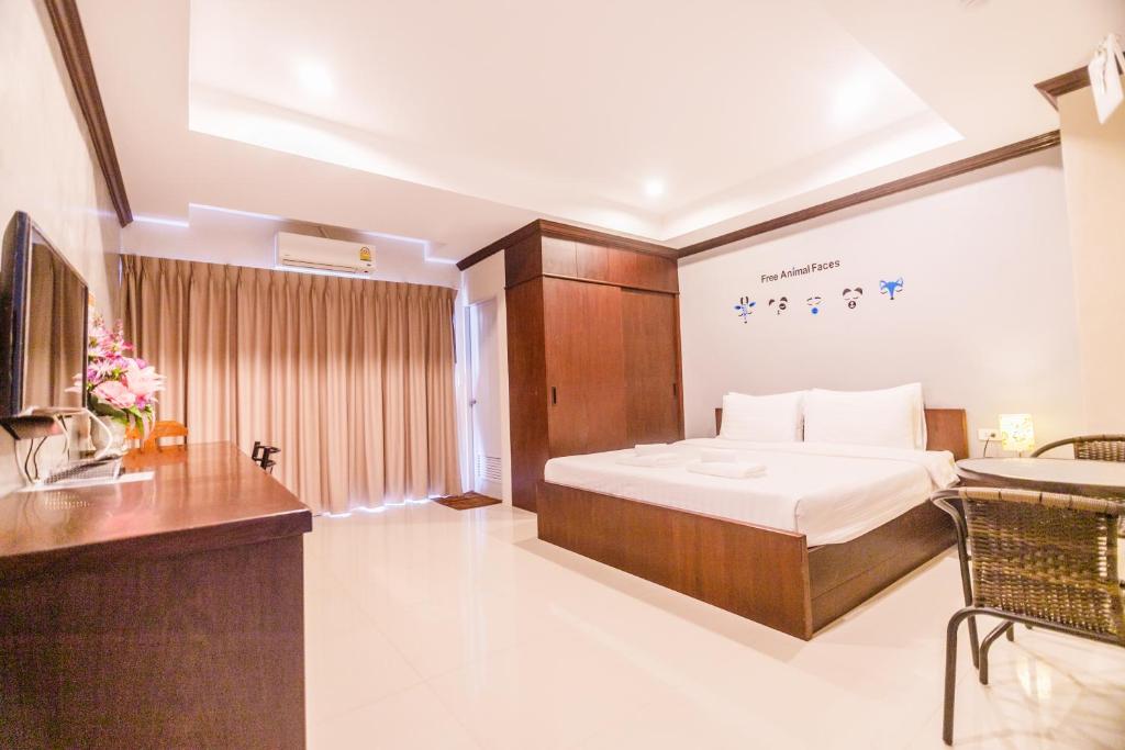 a bedroom with a bed and a desk and a sink at The Glasshouse place in Trang