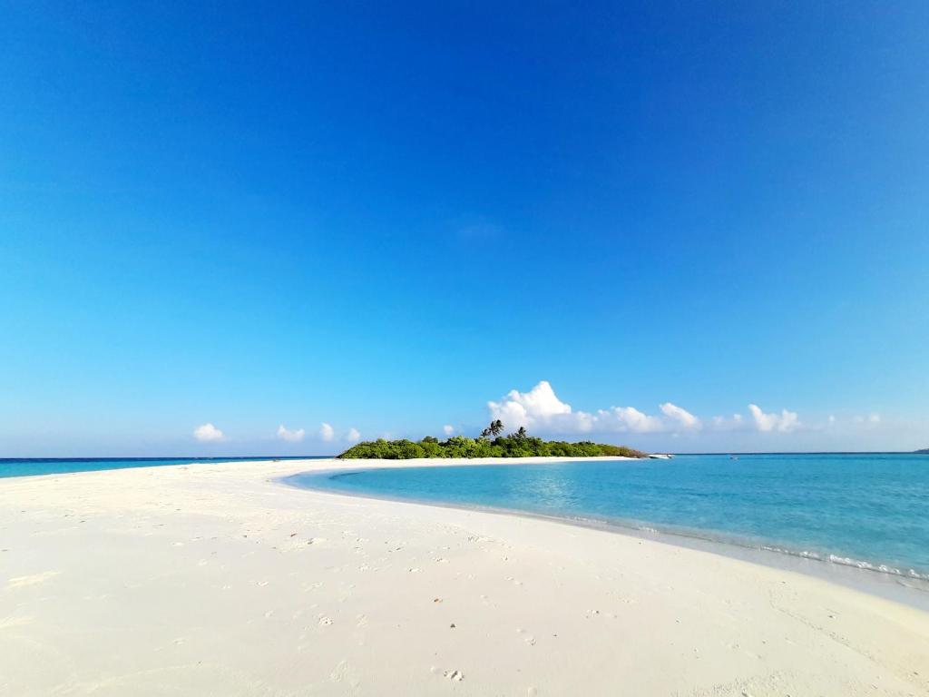 a small island in the ocean on a beach at Island Grand Maldives in Hangnaameedhoo