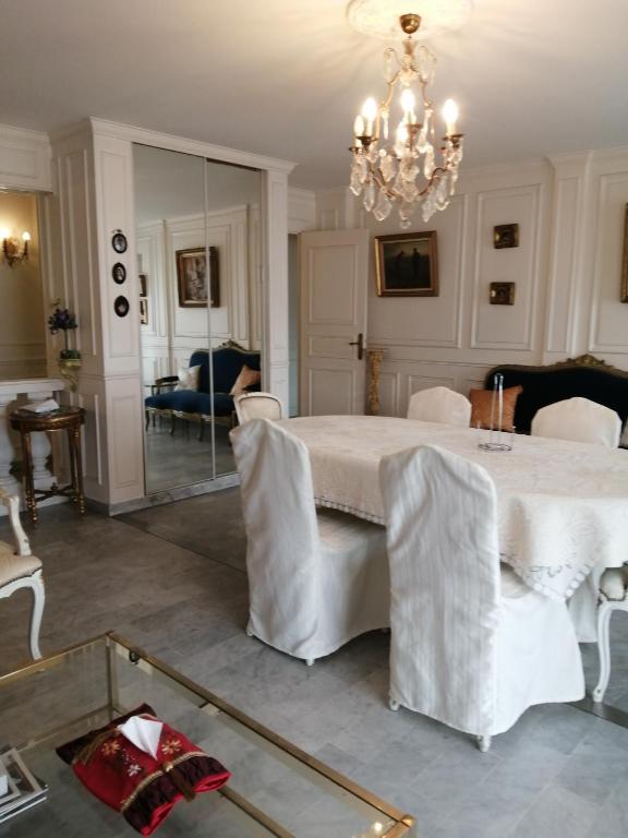 a dining room with a white table and a chandelier at Cannes Mimosas One Bedroom in Cannes
