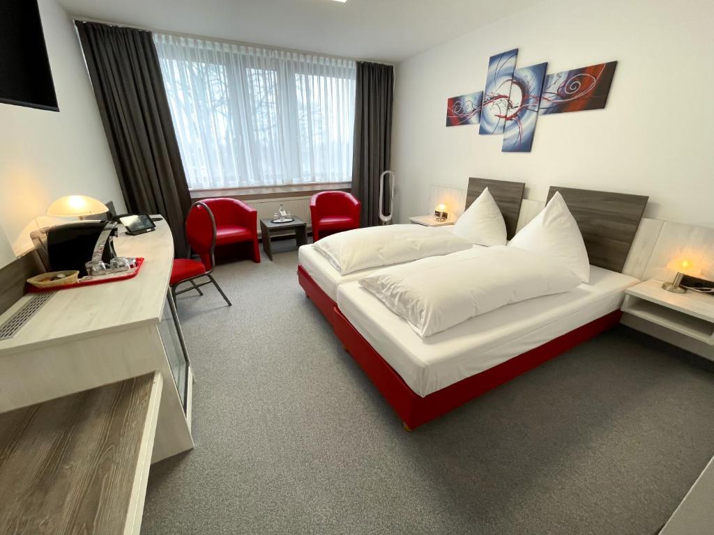 ein Hotelzimmer mit einem Bett, einem Schreibtisch und Stühlen in der Unterkunft Brenner Hotel in Bielefeld