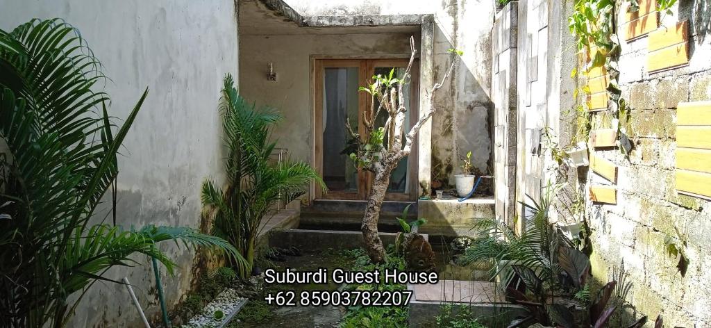 ein kleines Haus mit einer Treppe, die zu einer Tür führt in der Unterkunft Suburdi Guest House in Mujur