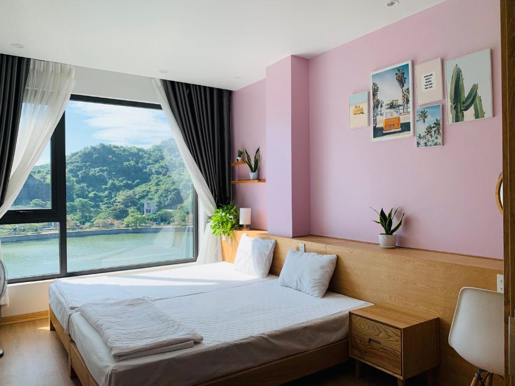 a bedroom with a bed with a large window at Rustic house in Cat Ba