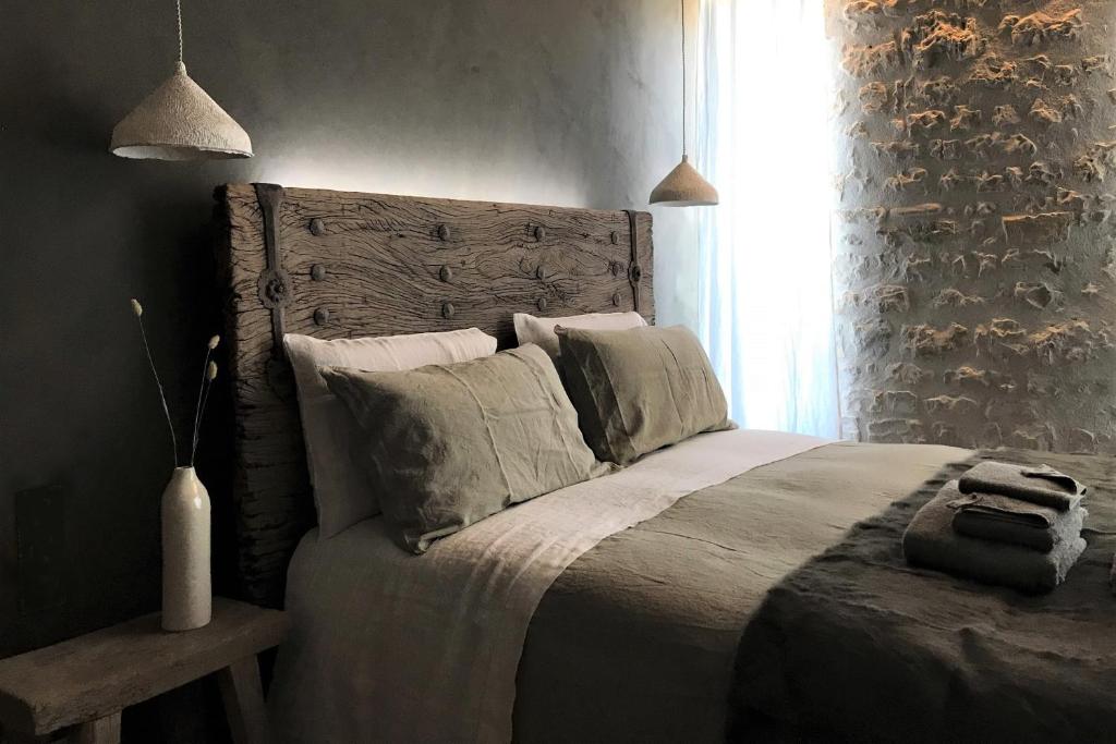 a bedroom with a large bed with a wooden headboard at Une Parenthèse in Sainte-Marie-de-Ré