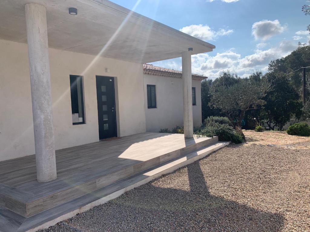 une terrasse couverte en bois d'une maison avec une porte bleue dans l'établissement Magnifique Villa classée 4* meublé de tourisme, à Flassans-sur-Issole