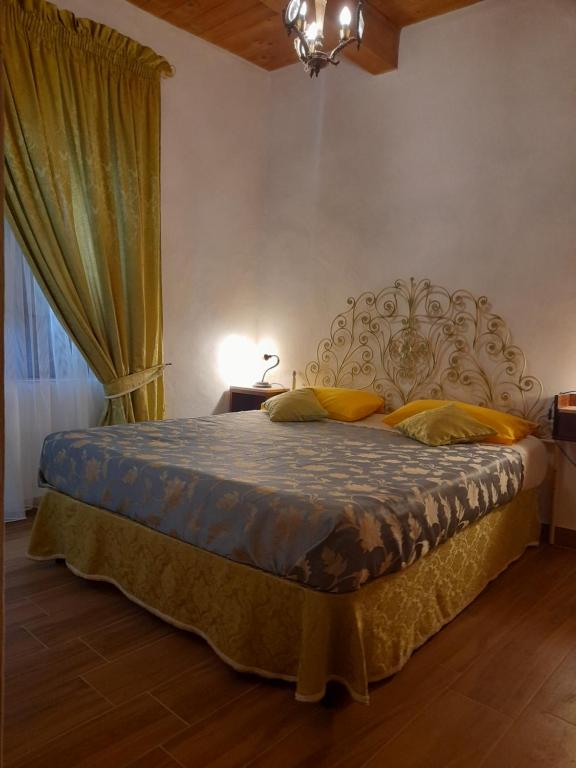 a bedroom with a large bed with yellow pillows at Casa Lanzara in Morano Calabro