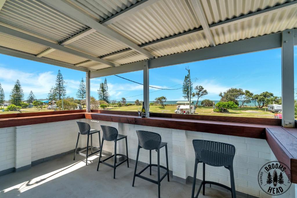 a patio with chairs and a bar with a view at Beachside at Brooms in Brooms Head