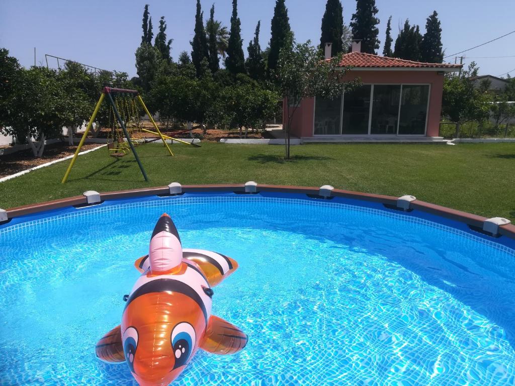 a pool with a inflatable dog in the water at Marathon Beachside Villa 100m from the beach in Schinias
