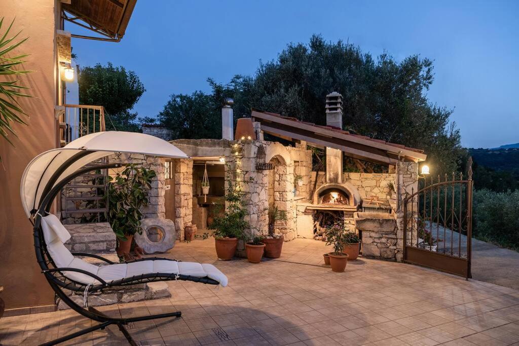 a patio with a chair and an outdoor oven at Villa Kritiko Archontiko in Koprána