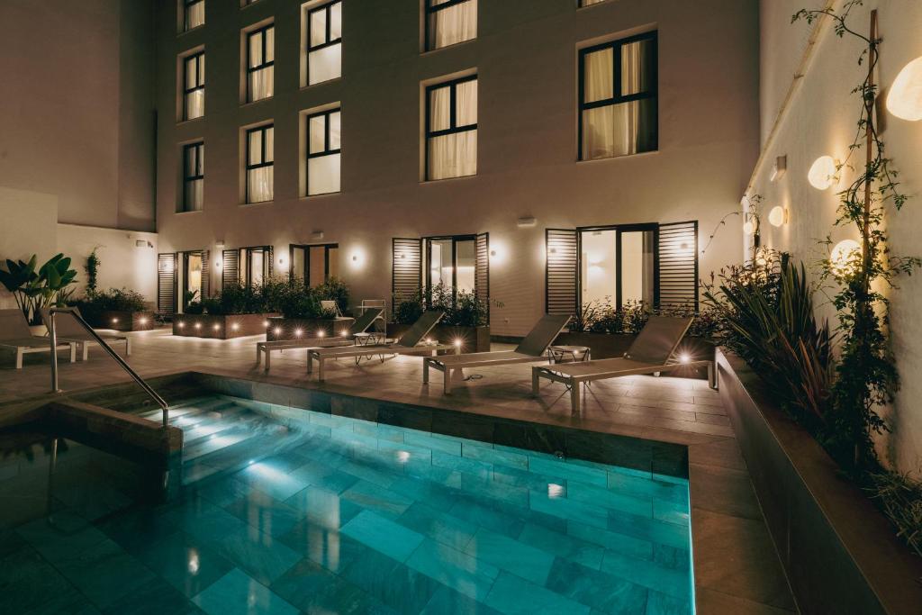 a hotel with a pool in front of a building at atLumbreras16 in Seville