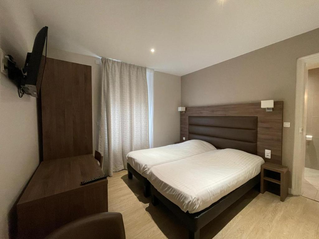 - une chambre avec un lit et une télévision dans l'établissement Royal Hôtel Angers, à Angers