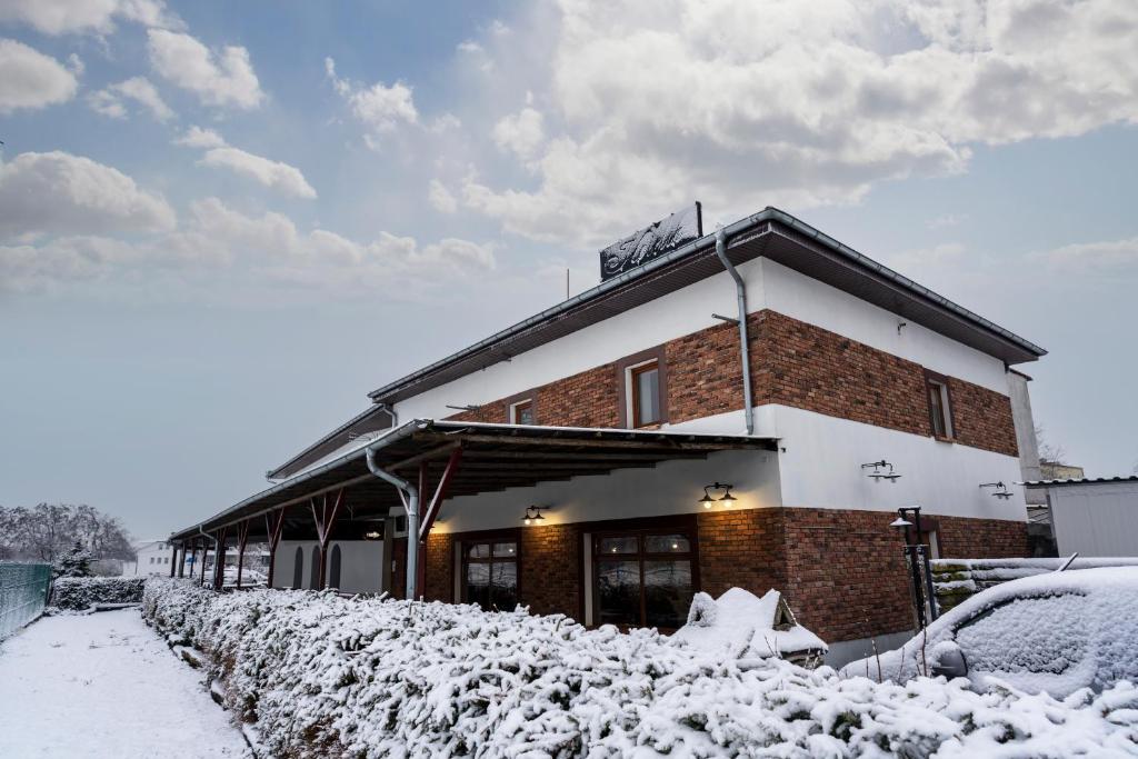 a building covered in snow with a car parked in front at Apartamentowiec Kuźniar in Kostrzyn nad Odrą