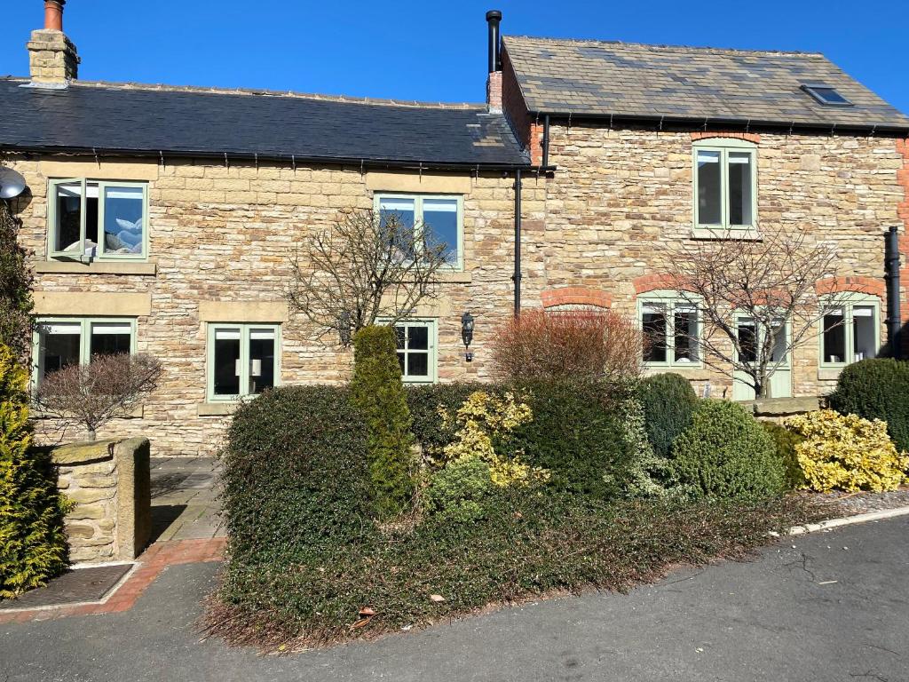 a brick house with a driveway in front of it at Honeysuckle Cottage in Oughtibridge