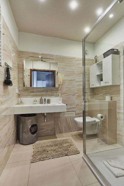 łazienka z umywalką, toaletą i lustrem w obiekcie Apartamenty Świnoujście - Aleja Baltic Park Molo C206 w Świnoujściu