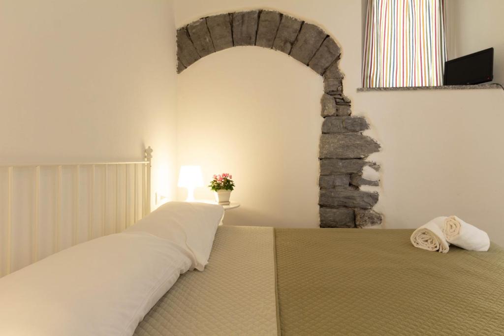 a bedroom with a bed with a stone wall at Mamma Ciccia in Mandello del Lario