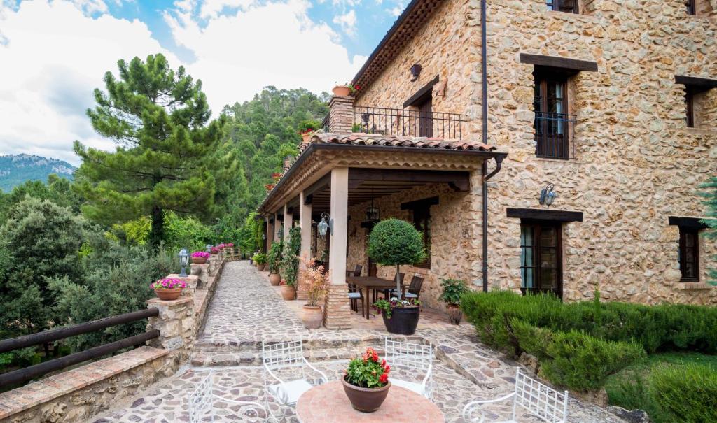 Casa de piedra con balcón y patio en Hotel de Montaña Cueva Ahumada, en Villaverde de Guadalimar
