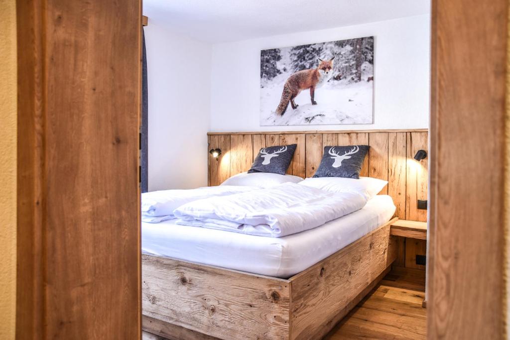 1 dormitorio con 1 cama con marco de madera en LUXX Lodges - Holzgau - Lechtal - Arlberg, en Holzgau