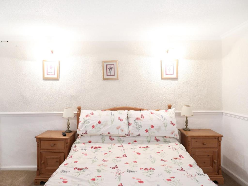 a bedroom with a bed and two night stands with lamps at The Willow Restaurant B&B in Pateley Bridge