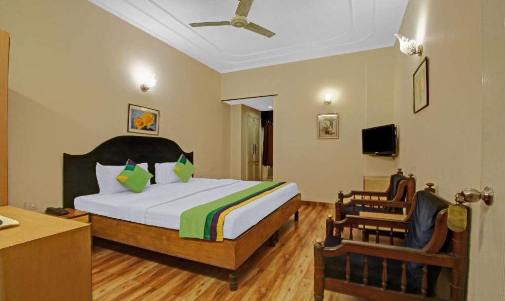 a bedroom with a bed and a desk and a chair at Treebo Trend Mira Inn in Kolkata