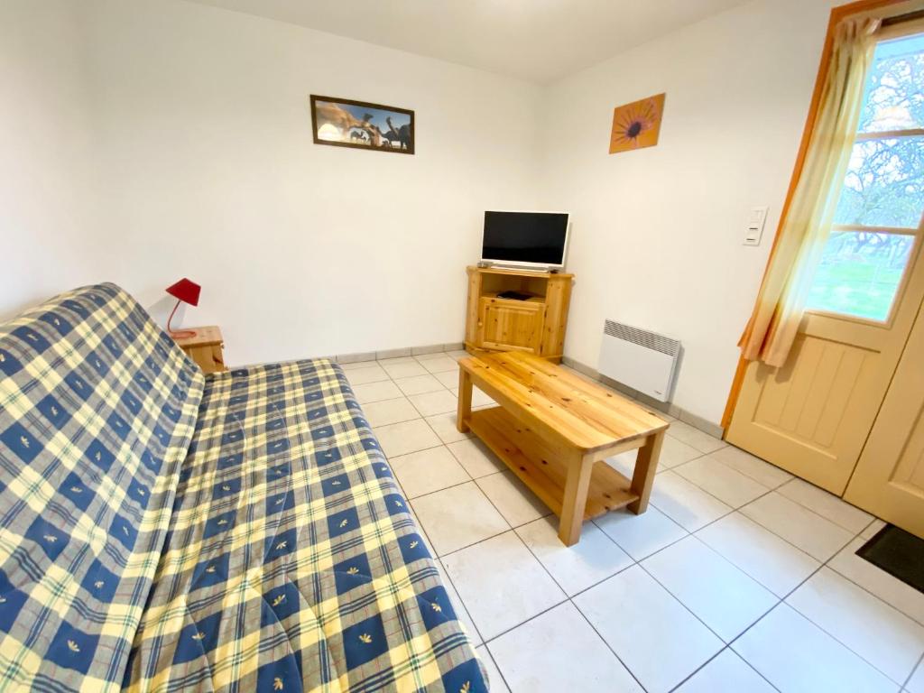 Zimmer mit Sofa, Tisch und TV in der Unterkunft Pommeraie et Eglantines in Quend