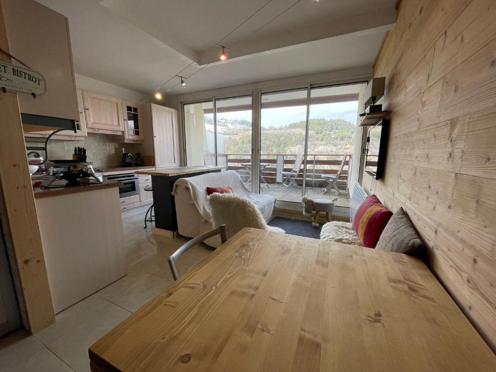 uma cozinha e sala de estar com uma mesa de madeira em le champas em Enchastrayes