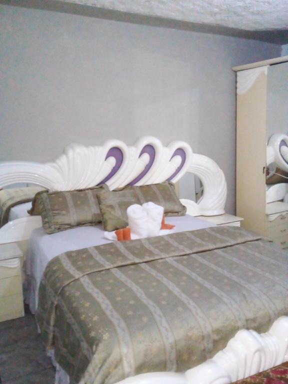 a bedroom with a bed with swans on it at Nine Miles Cultural Hangouts and Tours in Stepney