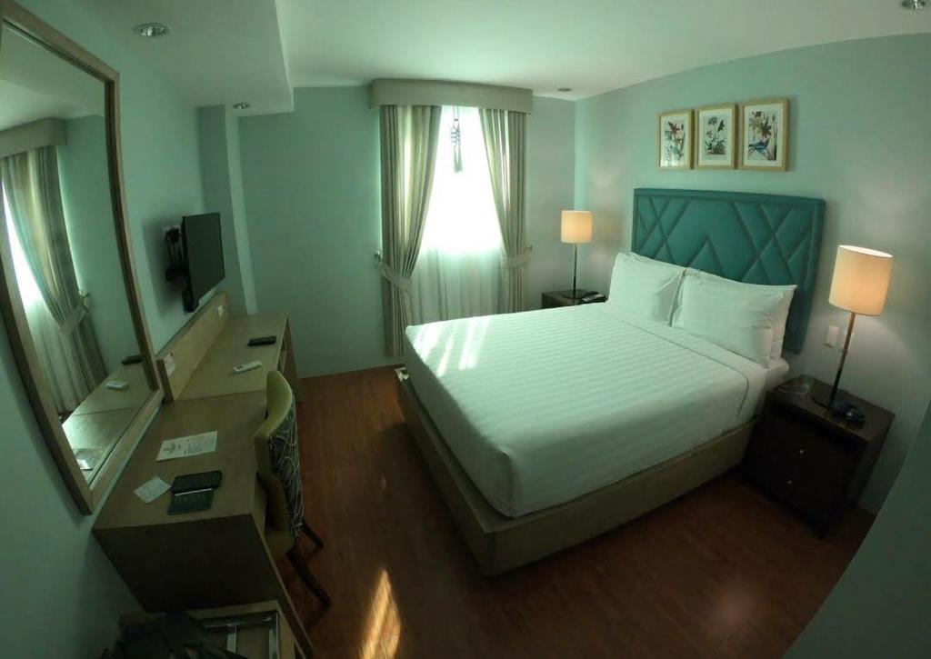 Postel nebo postele na pokoji v ubytování Dalian Peak Hotel