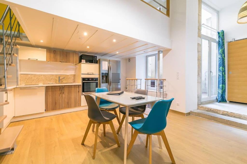 een keuken met een tafel en stoelen in een kamer bij Le Patio - SRLoc in Dijon
