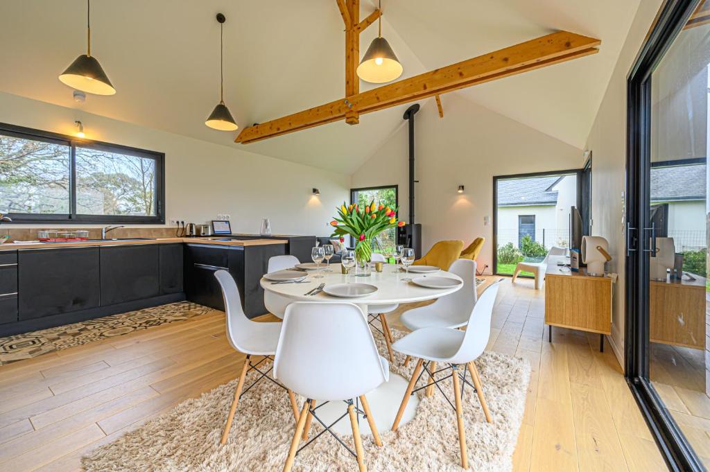 a kitchen and dining room with a table and chairs at LE GRAIN DE CHARME - Maison contemporaine proche golfe du Morbihan in Sarzeau
