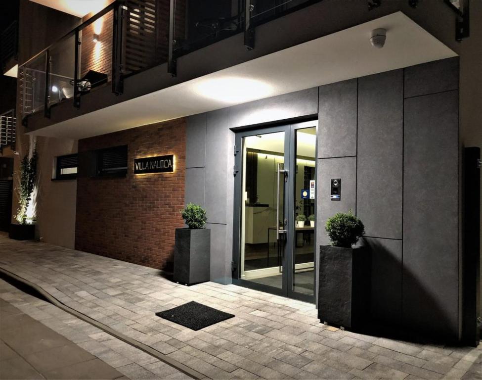 an entrance to a building with two potted plants at Villa Nautica in Łeba