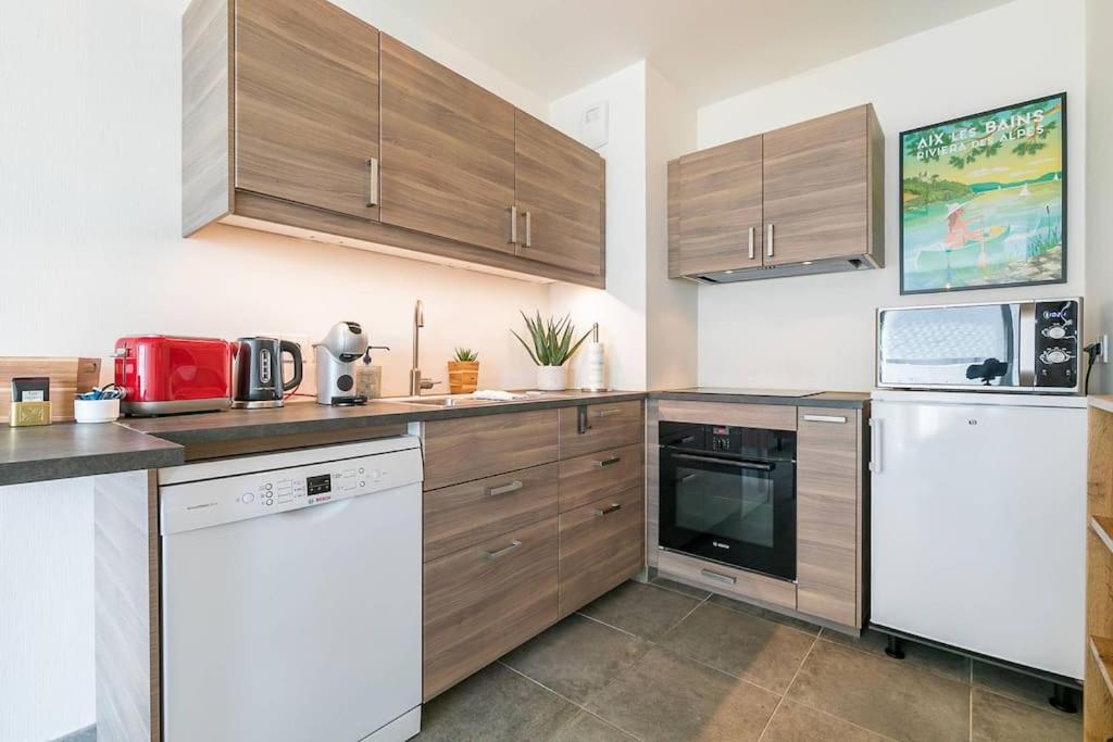 une cuisine avec des appareils électroménagers blancs et des armoires en bois dans l'établissement Le Carrousel, à Dijon