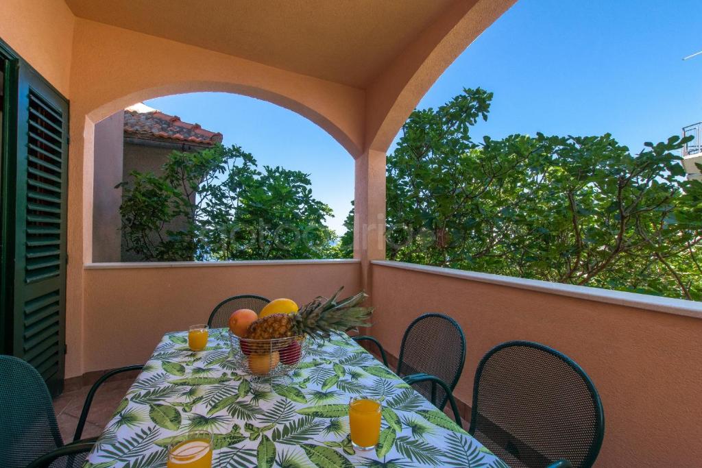 una mesa en un balcón con fruta en Near The Beach Brela Apartments Ruzze, en Brela