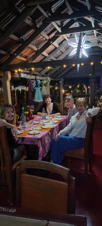 a group of people sitting at a table at Ambadi's villa -Lake view resort in Pallipuram