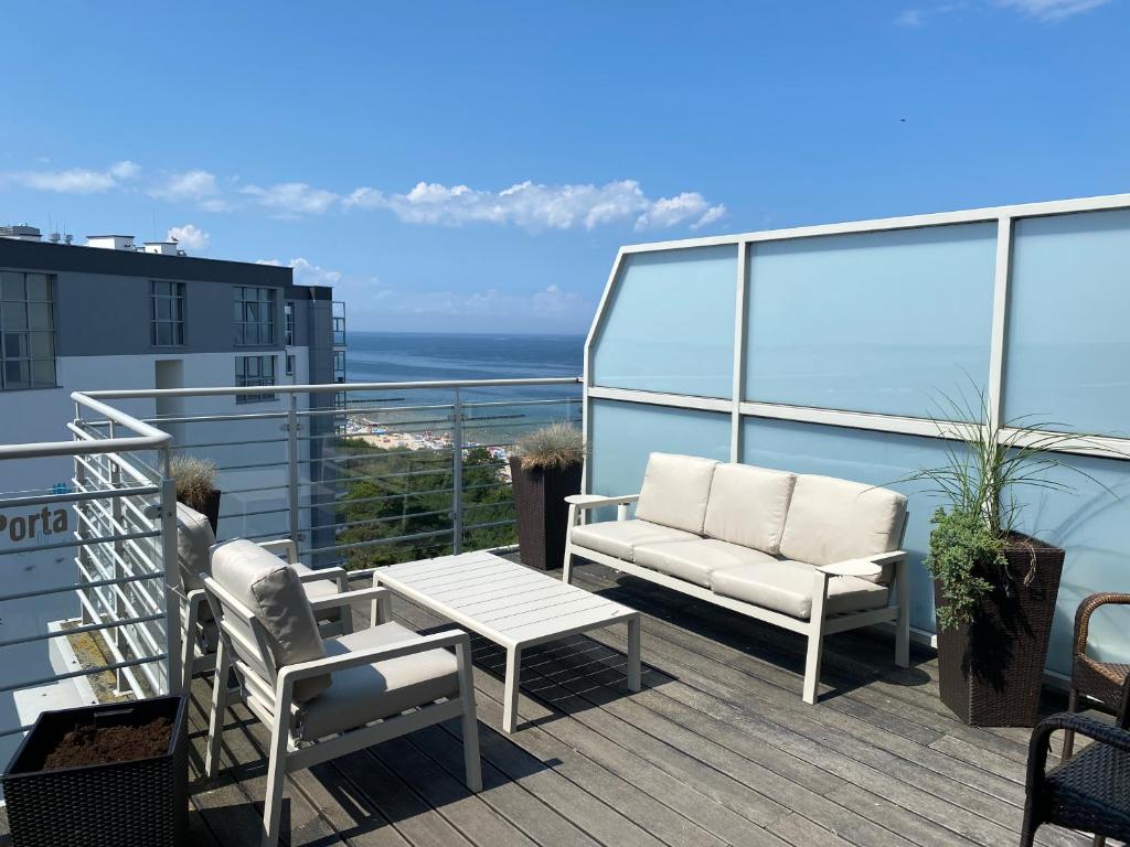 een balkon met 2 stoelen en een salontafel in een gebouw bij Apartamenty z widokiem na morze - przy plaży, SEA View in Dziwnówek