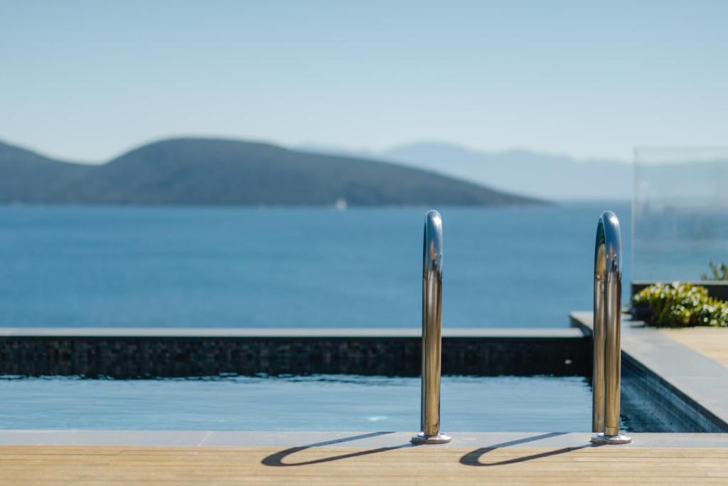 a swimming pool with two metal poles in front of it at METT Hotel & Beach Resort Bodrum in Bodrum City