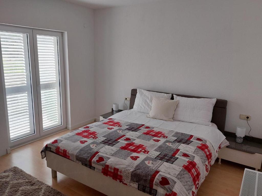 a bedroom with a bed with a quilt on it at Apartman Carpe Diem in Sutomišćica