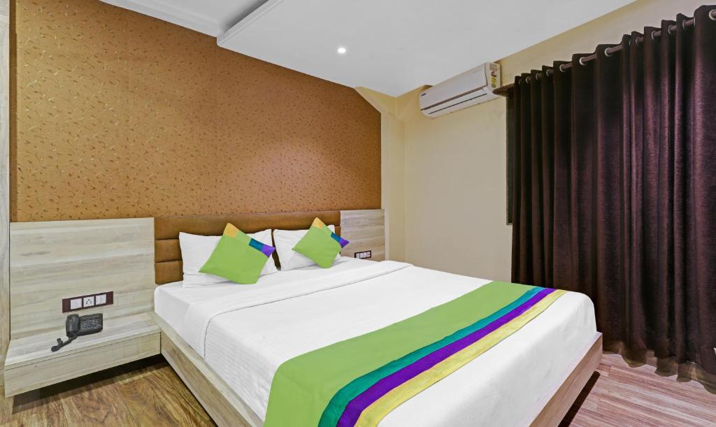 a bedroom with a large bed with a rainbow blanket at Treebo Trend Apollo in Guwahati