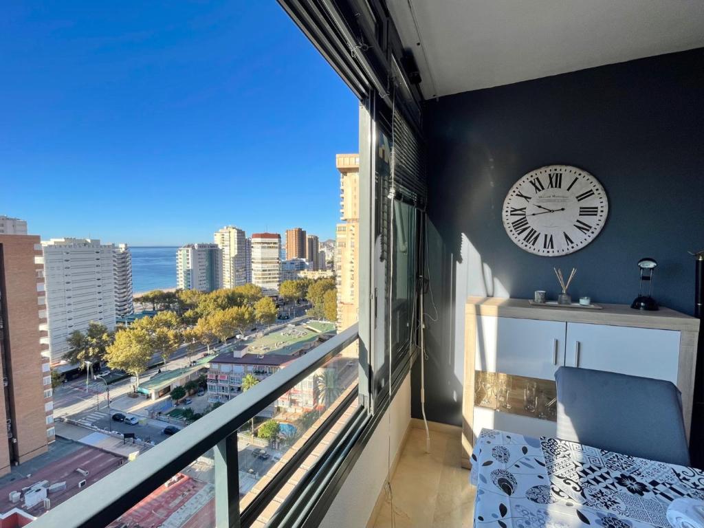 a room with a large window with a clock at Gerona Dream in Benidorm