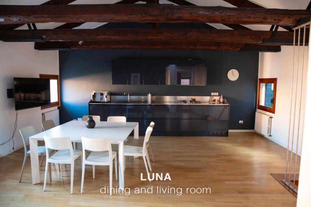 una cucina e una sala da pranzo con tavolo e sedie bianchi di Sole & Luna apartments a Venezia