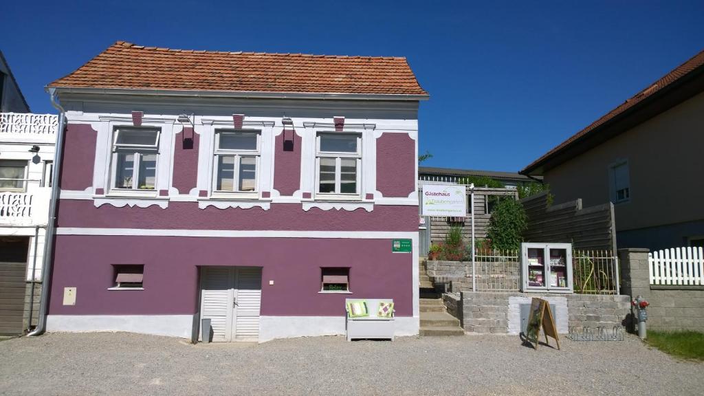 una casa viola e bianca con una finestra bianca di Traubengarten Winkler a Niederhollabrunn