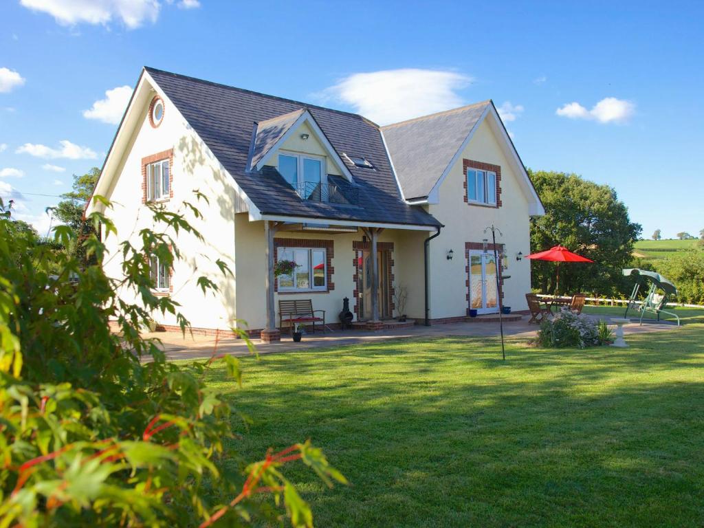 ein großes weißes Haus mit einem Rasenhof in der Unterkunft Henbere Farm B&B in Tiverton