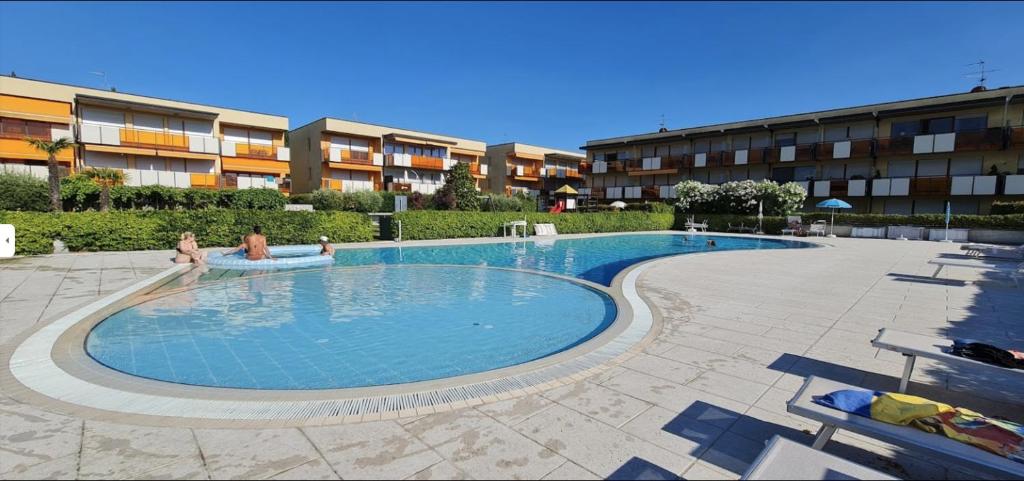 a swimming pool with two people sitting in it at Gardappartamenti Benacus Sirmione in Sirmione