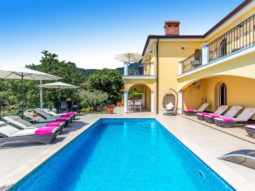 a villa with a swimming pool and lounge chairs at Holiday Home Villa Orhidea by Interhome in (( Marčići ))