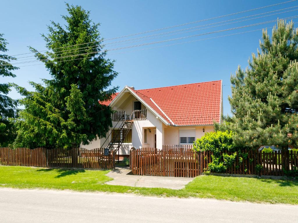 a house with a wooden fence and trees at Apartment Scarlett 2 by Interhome in Balatonszemes