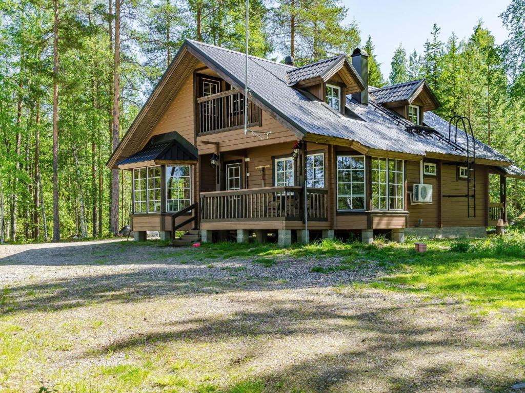 uma grande casa de madeira no meio de uma floresta em Holiday Home Lakunlahti by Interhome em Paalasmaa