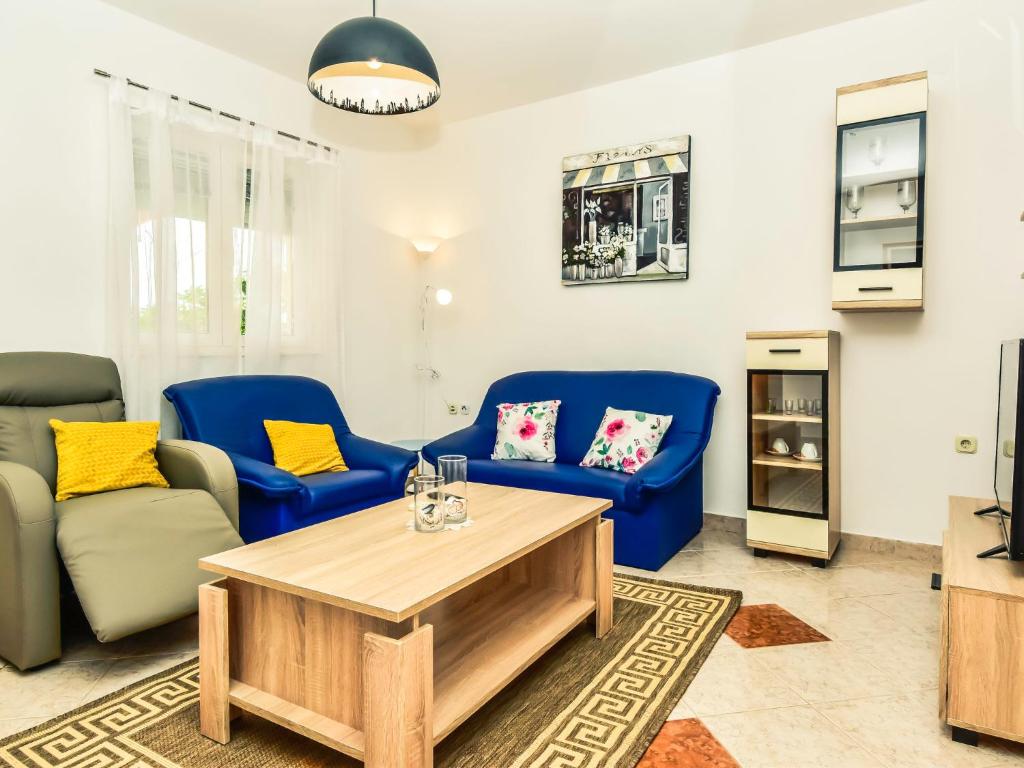 salon z niebieskimi krzesłami i stołem w obiekcie Apartment Dragica-1 by Interhome w mieście Podorjak